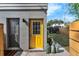 Exterior view of home with yellow door and backyard access at 2201 Delaney. Ave, Orlando, FL 32806