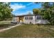 Charming home with a freshly painted exterior, a bright yellow front door, and neatly manicured lawn at 2201 Delaney. Ave, Orlando, FL 32806