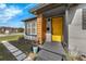 Inviting front porch with a striking yellow door, modern accents, and stylish landscaping at 2201 Delaney. Ave, Orlando, FL 32806
