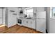 Well-lit kitchen with white cabinets, hardwood floors and stainless steel appliances at 2201 Delaney. Ave, Orlando, FL 32806
