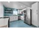 Modern kitchen with blue backsplash, white cabinets, and stainless steel appliances at 2201 Delaney. Ave, Orlando, FL 32806