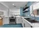 Bright kitchen features stainless steel appliances, white cabinetry, and unique geometric tile flooring and backsplash at 2201 Delaney. Ave, Orlando, FL 32806