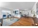 Bright, open-concept living room featuring hardwood floors, modern furnishings, and seamless flow to the kitchen at 2201 Delaney. Ave, Orlando, FL 32806