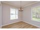 Dining room featuring hardwood floors, crown moulding and two large windows at 6893 Hidden Glade Pl, Sanford, FL 32771