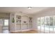 Bright living room featuring built-in shelving, hardwood floors and sliding glass doors with a view of the pool at 6893 Hidden Glade Pl, Sanford, FL 32771