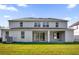 Two-story home showcasing a spacious backyard and a covered patio area with sliding glass doors at 3211 Eagle Watch Dr, Kissimmee, FL 34746