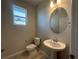 Small half-bathroom with tile floors featuring a pedestal sink and toilet with neutral paint at 9332 Bolshoi Aly, Winter Garden, FL 34787