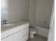 Bright bathroom featuring a white vanity with a sink, toilet, and a bathtub with white tile surround at 9332 Bolshoi Aly, Winter Garden, FL 34787