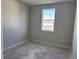 Bedroom showcasing one window, gray walls, and unfinished floors at 9332 Bolshoi Aly, Winter Garden, FL 34787