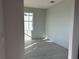 A bedroom featuring light gray walls and gray wood-look tiling illuminated by natural light from the window at 9332 Bolshoi Aly, Winter Garden, FL 34787