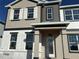 Two-story home featuring a mix of tan and gray siding, white framed windows, and a covered front porch at 9332 Bolshoi Aly, Winter Garden, FL 34787