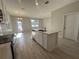 Contemporary kitchen features a center island with a sink, light wood-style flooring and a bright, open design at 9332 Bolshoi Aly, Winter Garden, FL 34787