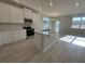 Bright, all-white kitchen features a center island with a sink, stainless steel appliances, and a light, open floor plan at 9332 Bolshoi Aly, Winter Garden, FL 34787
