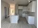 Kitchen featuring white cabinetry, island, stainless steel sink, and wood-look tile floors at 9332 Bolshoi Aly, Winter Garden, FL 34787