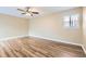 Cozy bedroom with hardwood floors, neutral-toned walls, and natural light from a window at 1009 Perkins St, Leesburg, FL 34748