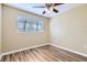 This cozy bedroom has wood-look floors, a ceiling fan and natural light at 1009 Perkins St, Leesburg, FL 34748