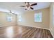 Oversized bedroom featuring hardwood floors, ceiling fans and natural light from two windows at 1009 Perkins St, Leesburg, FL 34748