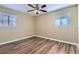 Well-lit bedroom with neutral walls, hardwood flooring, ceiling fan, and window at 1009 Perkins St, Leesburg, FL 34748