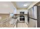 Modern kitchen boasting stainless steel appliances, granite countertops, and pristine white cabinets at 1009 Perkins St, Leesburg, FL 34748