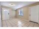 Bright living room featuring neutral walls, tile flooring, a large window, and multiple entry doors at 1009 Perkins St, Leesburg, FL 34748