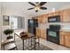 Kitchen featuring wood cabinets, black appliances, a window, and an eat in area with table and chairs at 11 Escondido Cir # 109, Altamonte Springs, FL 32701