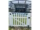 A backyard view showcasing a screened pool area, enclosed by a classic white picket fence for added privacy and charm at 1952 Dunn Cove Dr, Apopka, FL 32703
