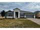 Single-story home with gray siding, stone accents, and a two-car garage at 371 Lady Palm St, Apopka, FL 32703