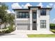 Modern two-story home with a balcony, two-car garage, and well-manicured landscaping at 1026 Jack Nicklaus Ct, Kissimmee, FL 34747