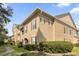 Well-maintained condo with neutral tones, brown shutters, manicured bushes, and green grass at 14304 Fredricksburg Dr # 420, Orlando, FL 32837