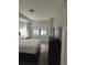 Bedroom featuring a dark dresser, a queen bed with white linens, and a window offering natural light at 14501 Grove Resort Ave # 1332, Winter Garden, FL 34787
