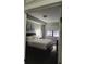 Bright bedroom featuring a dark wood bed frame, white linens, and a window with roller shades at 14501 Grove Resort Ave # 1332, Winter Garden, FL 34787