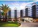 Exterior shot of multi-story building with large entrance and manicured lawn surrounded by palm trees at 14501 Grove Resort Ave # 1332, Winter Garden, FL 34787