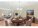 Bright dining room features a wood table and chairs, hardwood floors, and stylish light fixture at 2871 Sandy Cay St, Clermont, FL 34711