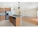 Open kitchen boasts an island, granite countertops, and stainless steel appliances at 2871 Sandy Cay St, Clermont, FL 34711