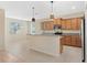 Modern kitchen with wood cabinets, granite countertops, and stainless steel appliances at 2871 Sandy Cay St, Clermont, FL 34711