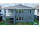 A modern two-story home features a covered patio, second-story balcony, and multiple windows for ample natural light at 5648 Green Arrow Pl, Sanford, FL 32773
