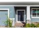 Inviting front entrance with a stylish dark door and stone accents providing an appealing look at 5648 Green Arrow Pl, Sanford, FL 32773