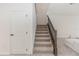 Carpeted staircase leading to the upper level with iron railing and white trim at 5648 Green Arrow Pl, Sanford, FL 32773