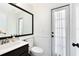 Well-lit bathroom with a large mirror, vanity sink, and a door leading to the outside at 2815 Crane Trace Cir, Orlando, FL 32837