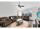 Spacious living room featuring a cozy brown sofa, a ceiling fan, and ample natural light at 2815 Crane Trace Cir, Orlando, FL 32837
