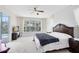Bright main bedroom with a ceiling fan, large window overlooking the backyard, and plush carpet at 2815 Crane Trace Cir, Orlando, FL 32837