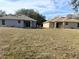 Backyard of two single-story homes with green grass and blue skies at 6921 Central Ave, Mulberry, FL 33860