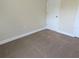 Simple bedroom with neutral carpeting and a door at 6921 Central Ave, Mulberry, FL 33860