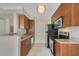Galley kitchen with wood cabinets and granite counters at 11574 Westwood Blvd # 1112, Orlando, FL 32821