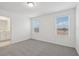 Bedroom with two windows, grey carpet and ensuite bathroom at 16387 Happy Eagle Dr, Clermont, FL 34714