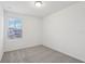 Bright bedroom with grey carpet, window, and neutral walls at 16387 Happy Eagle Dr, Clermont, FL 34714