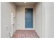 Front entry of townhome with brick flooring and a blue door at 16387 Happy Eagle Dr, Clermont, FL 34714