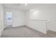 Upstairs hallway with gray carpet and access to bedrooms at 16387 Happy Eagle Dr, Clermont, FL 34714