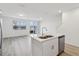 Modern kitchen island with double sink, stainless steel appliances, and vinyl flooring at 16387 Happy Eagle Dr, Clermont, FL 34714