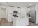 Modern kitchen with white cabinets, center island, and stainless steel appliances at 16387 Happy Eagle Dr, Clermont, FL 34714